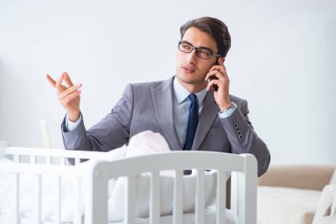 Genç iş adamı yeni doğmuş bebeğe evde bakmaya çalışıyor.