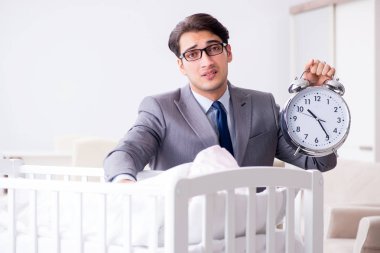 Genç işadamı yeni doğduktan sonra evde çalışmaya çalışıyor. 