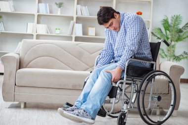 Evde acı çeken engelli genç adam.