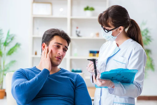 Doctor checking patients ear during medical examination