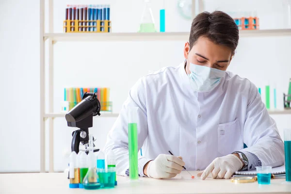 Joven estudiante de química trabajando en laboratorio sobre productos químicos —  Fotos de Stock