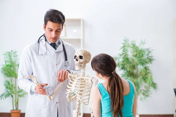 Medico che mostra il tipo di lesione sullo scheletro al paziente — Foto Stock