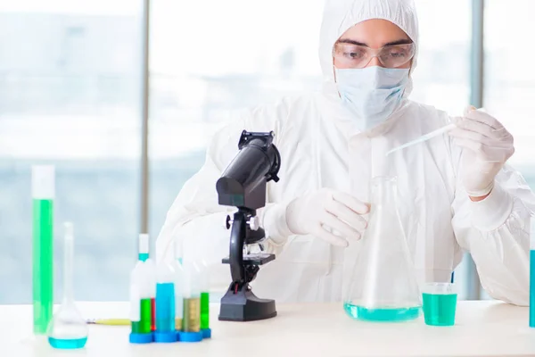 Jovem estudante de química que trabalha em laboratório em produtos químicos — Fotografia de Stock