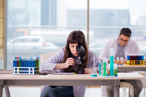 Dois químicos que trabalham em laboratório experimentando — Fotografia de Stock