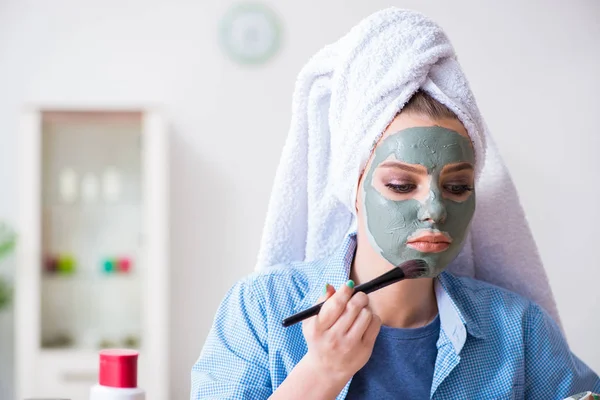Kvinna tillämpa lera mask med borste hemma — Stockfoto