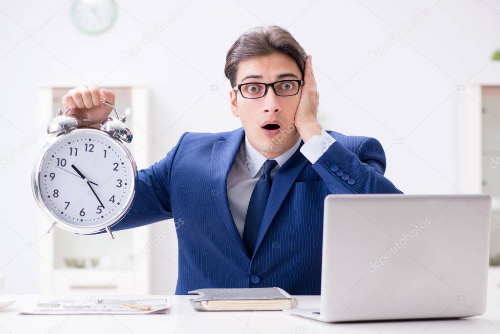 Businessman employee in urgency and deadline concept with alarm 
