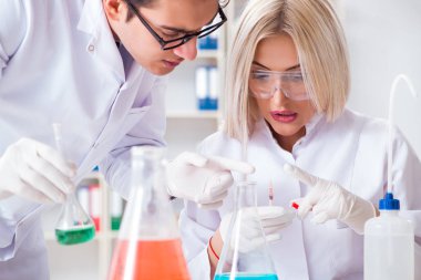 Laboratuvarda tartışan iki kimyager.