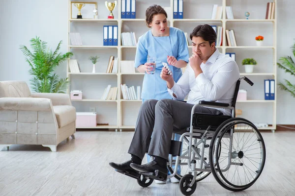 Paziente disabile in sedia a rotelle visita dal medico per un controllo regolare — Foto Stock