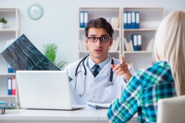 Doktor hastanın röntgen görüntülerini inceliyor.