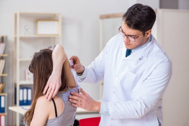 Doktor hastaların eklem esnekliğini kontrol ediyor