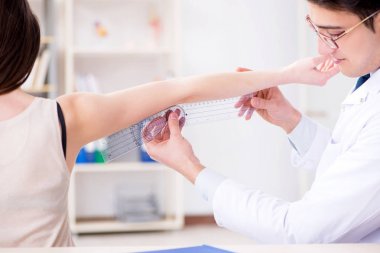 Doktor hastaların eklem esnekliğini gonimetreyle kontrol ediyor.