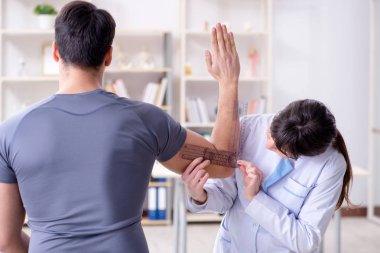 Doktor hastaların eklem esnekliğini gonimetreyle kontrol ediyor.