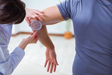 Doktor hastaların eklem esnekliğini gonimetreyle kontrol ediyor.