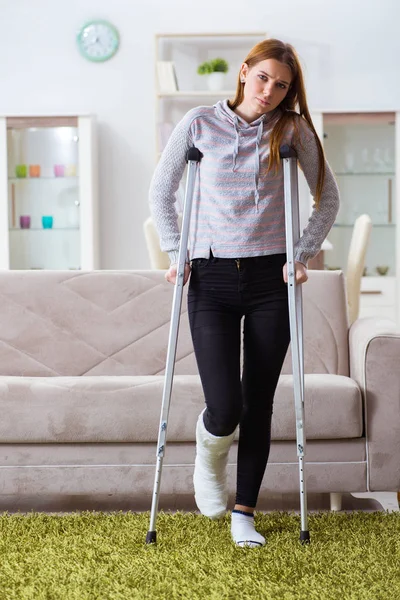 Young woman with broken leg at home — Stock Photo, Image