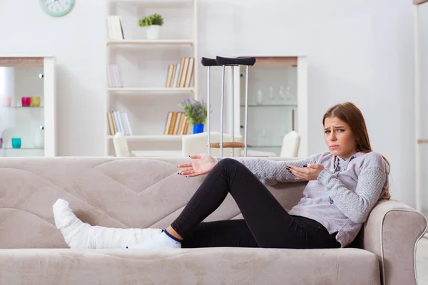 Mujer joven con la pierna rota en casa — Foto de Stock