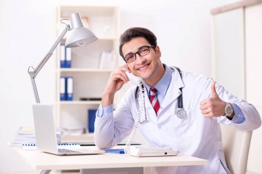 Hastane odasında çalışan yakışıklı genç bir doktor.