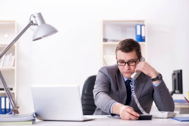 İşadamı ofis telefonundan konuşuyor.