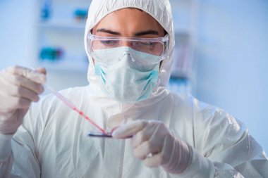 Laboratuvar asistanı hastanede kan örneklerini test ediyor.