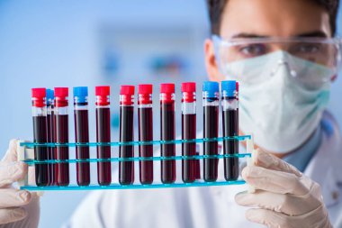 Laboratuvar asistanı hastanede kan örneklerini test ediyor.