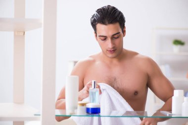 Genç adam banyoda çalışmak için hazırlanıyor.