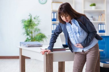 Ofiste çalışmak için çırpınan hamile bir kadın.