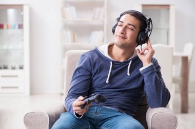 Genç adam evde bilgisayar oyunu oynuyor.