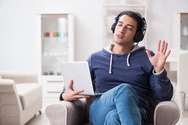 Jonge knappe man die naar muziek luistert met koptelefoon — Stockfoto