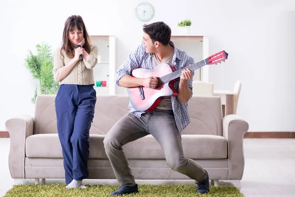 Jonge familie die thuis muziek zingt en speelt — Stockfoto