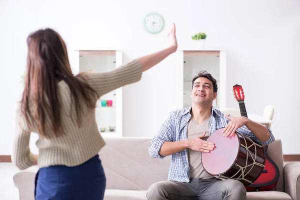 Jonge familie die thuis muziek zingt en speelt — Stockfoto