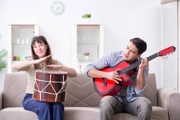 Jonge familie die thuis muziek zingt en speelt — Stockfoto