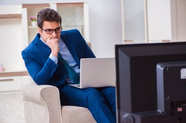 İş adamı ofiste televizyon izliyor.