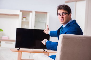 İş adamı ofiste televizyon izliyor.