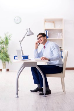 İşadamı ofis telefonundan konuşuyor.