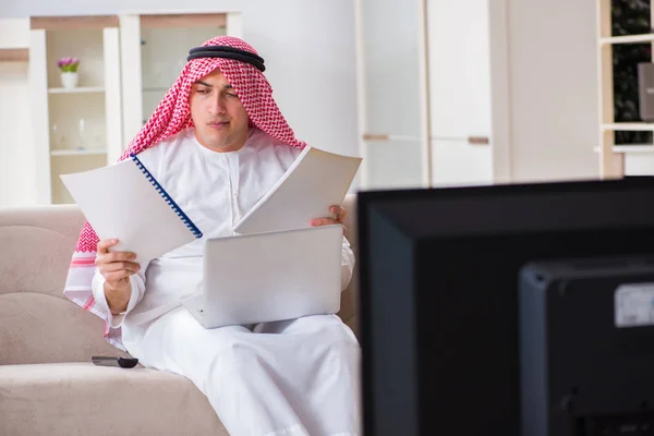 Arab businessman watching tv at home