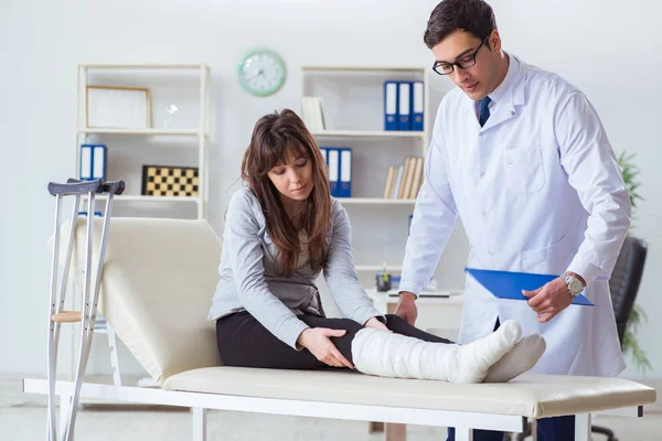 Doktor vyšetřuje pacienta se zlomenou nohou — Stock fotografie