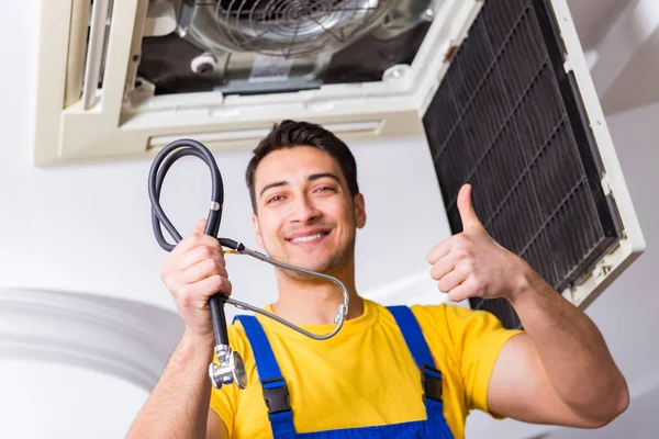 Repairman repairing ceiling air conditioning unit