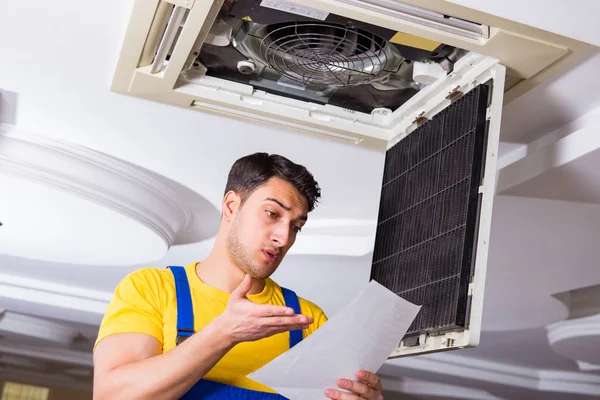 Reparador reparando unidade de ar condicionado teto — Fotografia de Stock