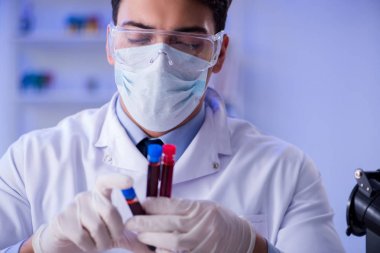 Laboratuvar asistanı hastanede kan örneklerini test ediyor.