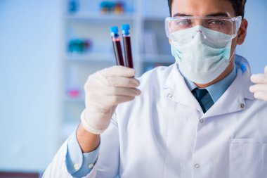 Laboratuvar asistanı hastanede kan örneklerini test ediyor.