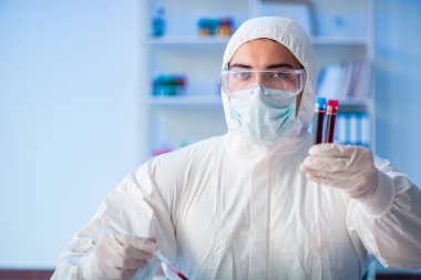 Laboratuvar asistanı hastanede kan örneklerini test ediyor.