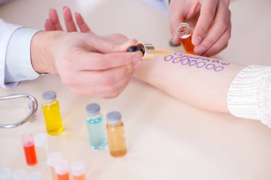 Hastanedeki hastanın alerji reaksiyonunu test eden doktor.