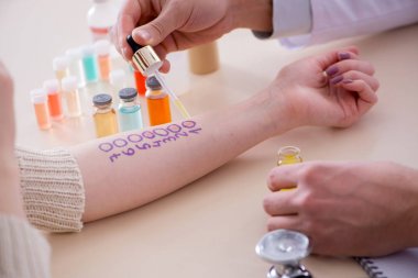 Hastanedeki hastanın alerji reaksiyonunu test eden doktor.