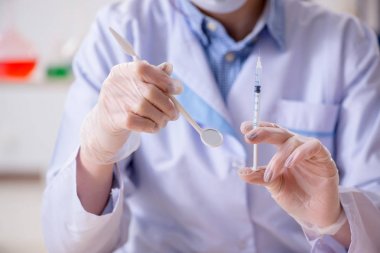 Diş hekimi, diş modeli üzerinde çalışıyor.