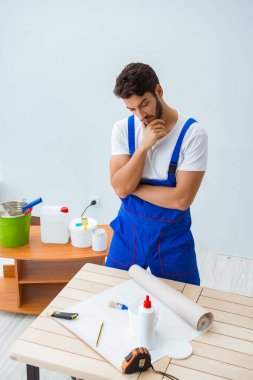 Tadilat sırasında duvar kâğıdı üzerinde çalışan işçiler