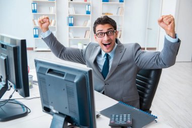 Birçok ekranın önünde oturan bir iş adamı