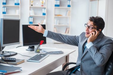 Birçok ekranın önünde oturan bir iş adamı