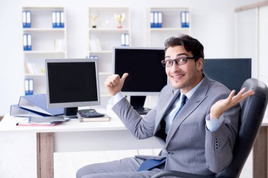Birçok ekranın önünde oturan bir iş adamı