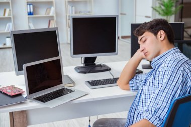 Birçok ekranın önünde oturan bir iş adamı