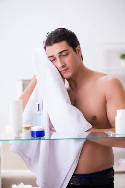 Genç adam banyoda çalışmak için hazırlanıyor.
