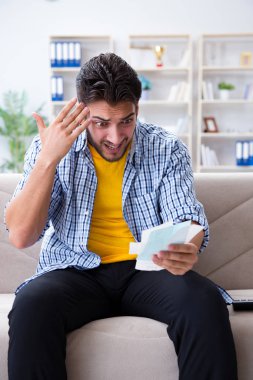 Ödeme yapması gereken faturalara kızgın bir adam.